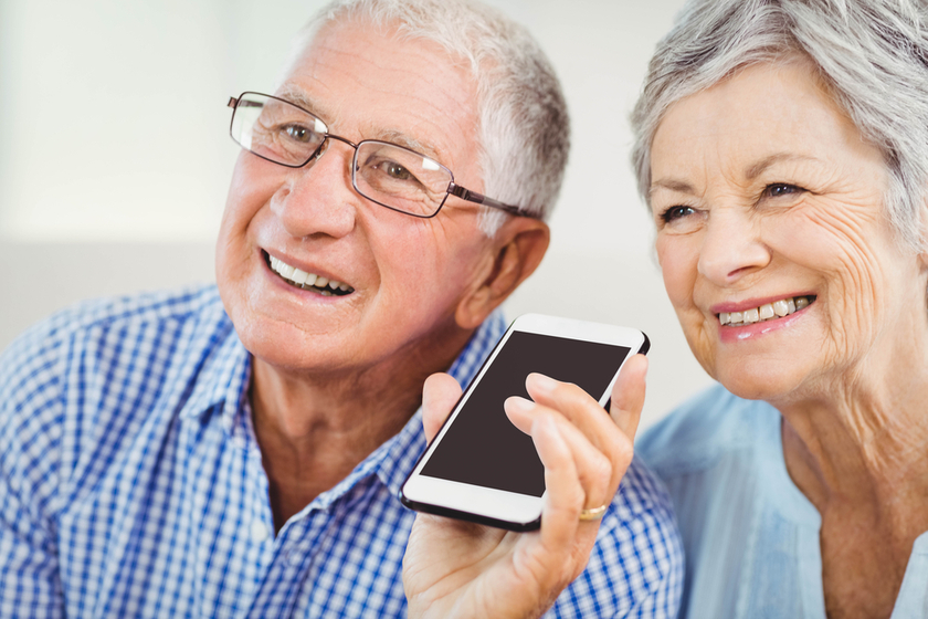 Senior couple smiling while talking on mobile phone
