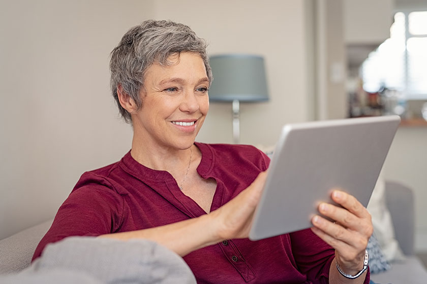 Smiling senior woman looking her digital tablet