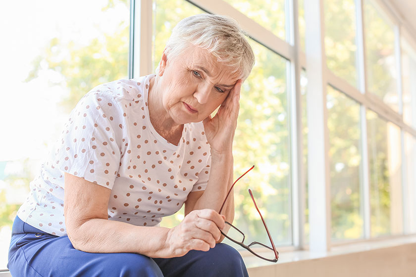 Stressed senior woman suffering from headache